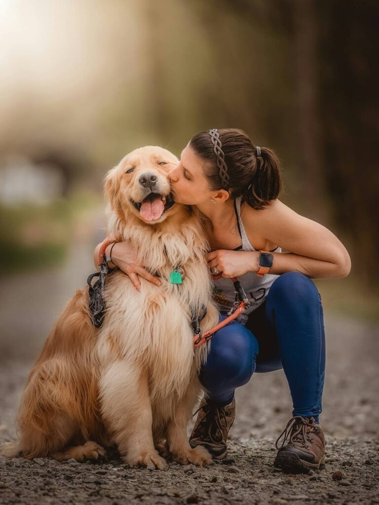 Young girl sitting with golden retriever Max outdoors, cherished memory for online pet memorial UK