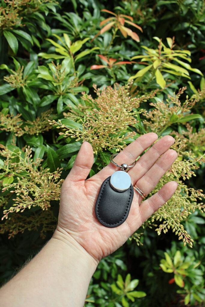 person holding pet memorial NFC keychain UK that links to online tribute page