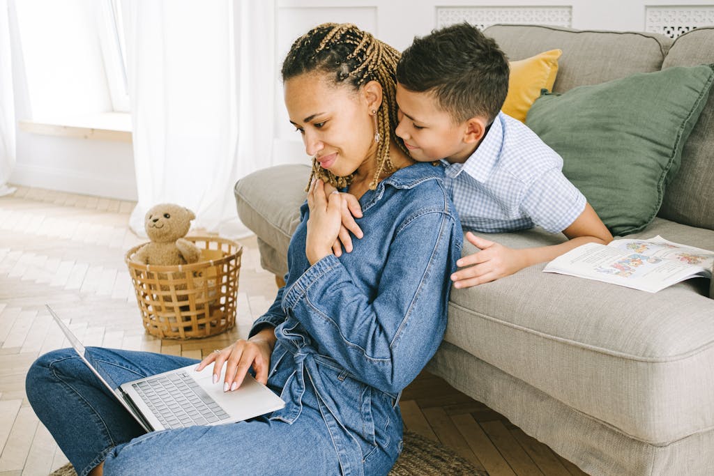 Mother and child sitting together with a laptop, sharing memories in a warm family setting.